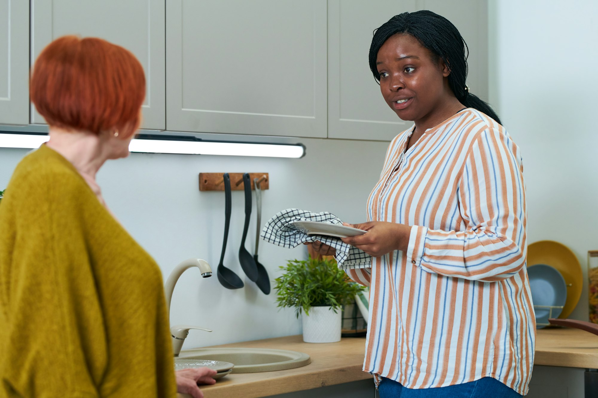 Caregiver helping elderly woman with chores