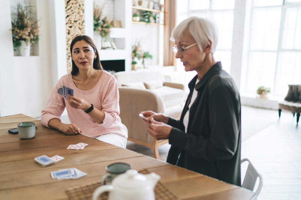 Happy diverse friends playing card game together at home