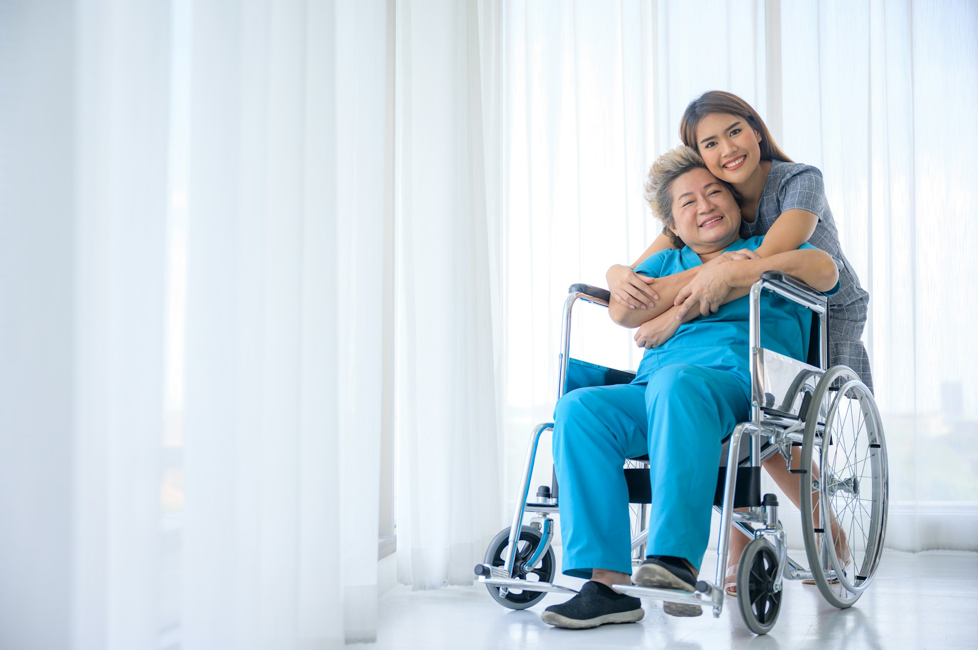 Happy patient is holding caregiver for a hand while spending time together